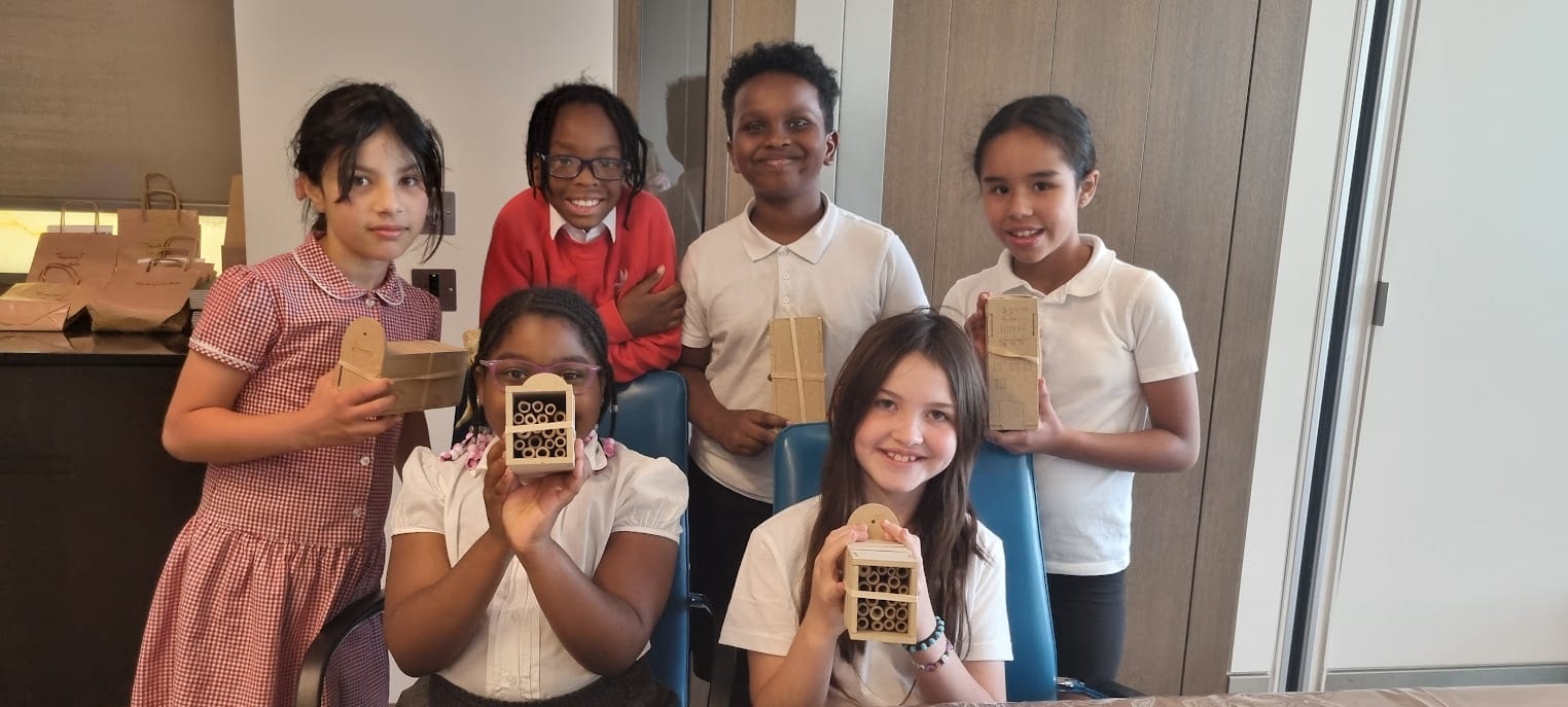 A group of pupils proudly display their completed bee hotels